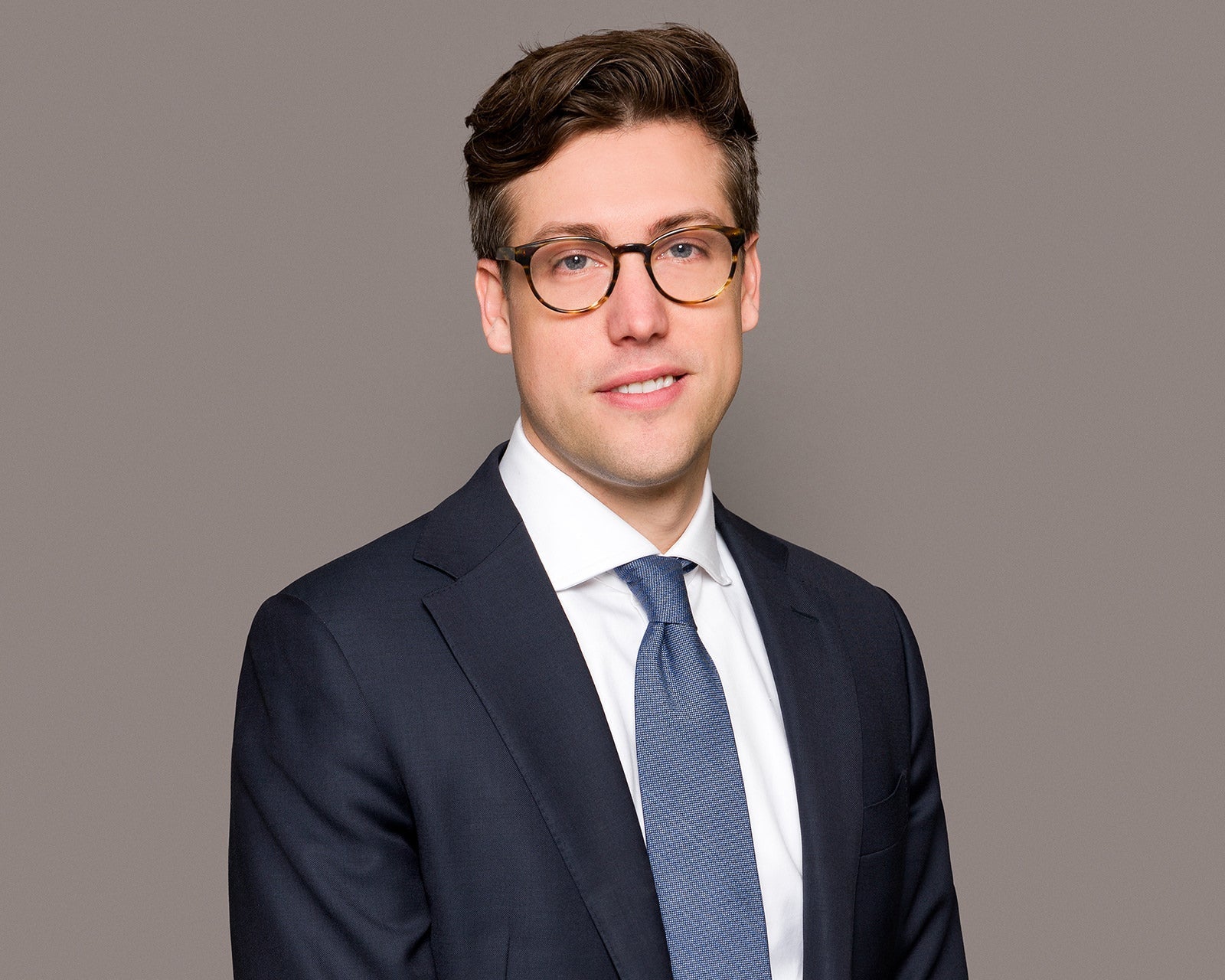 A corporate headshot on a clean background, chest-up crop, business formal attire