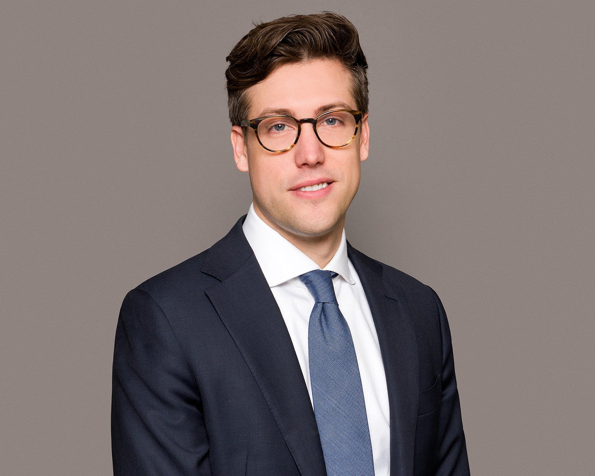 A corporate headshot on a clean background, chest-up crop, business formal attire