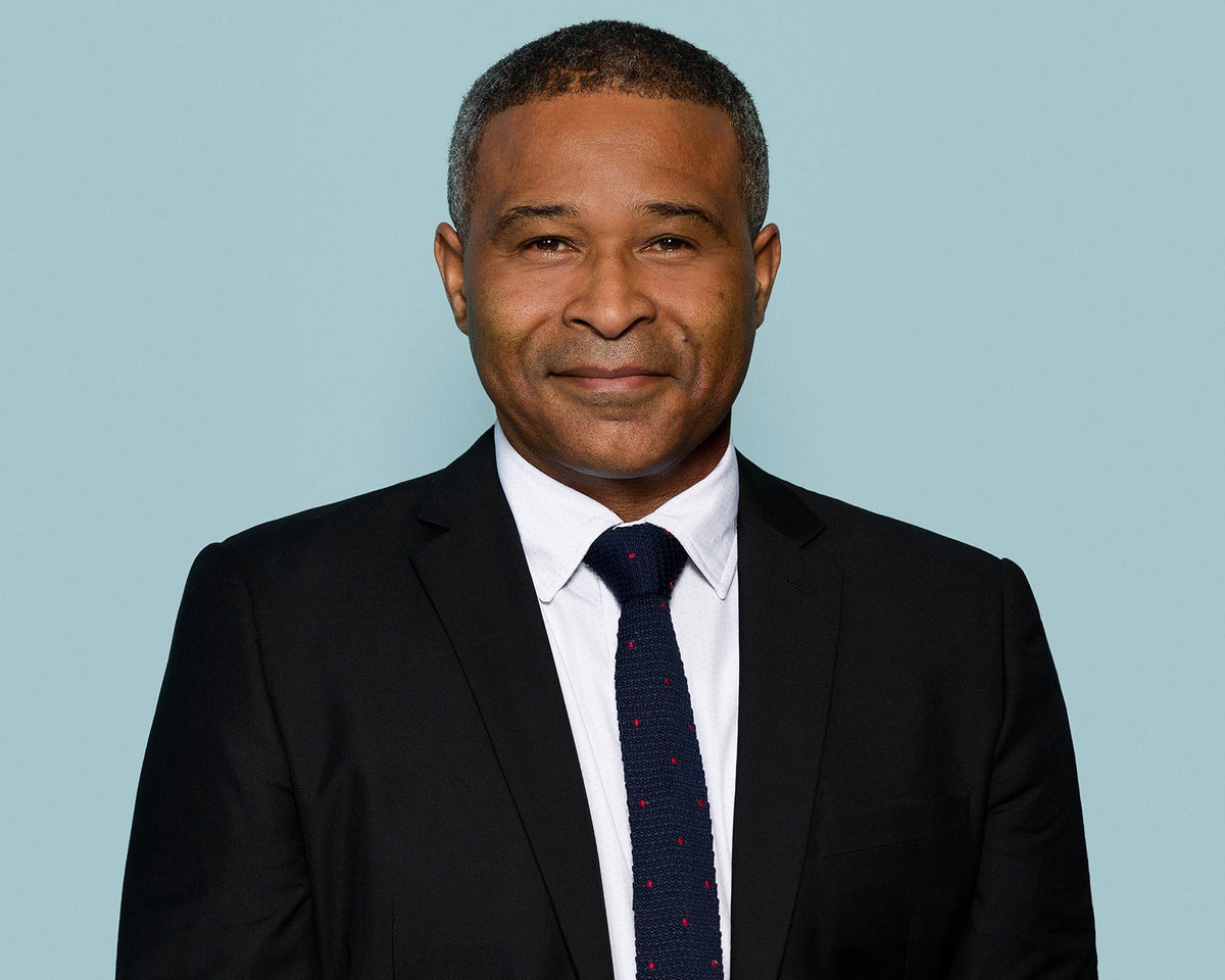 Corporate headshot of a mid-career professional against a soft blue background