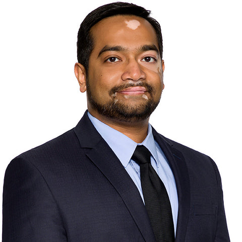 Lawyer headshot of a bearded man in a navy suit on the same white-background standard