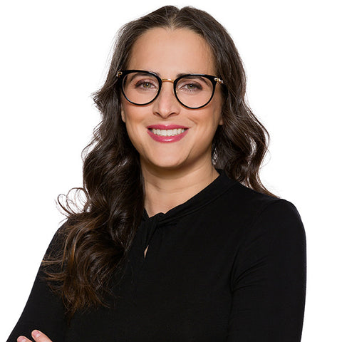 Lawyer headshot of a woman in glasses and a black top, on the same firm headshot standard