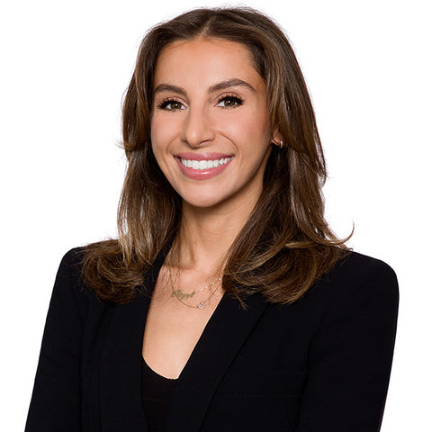 Law firm headshot of a woman lawyer with long brown hair in a black blazer, white-background standard