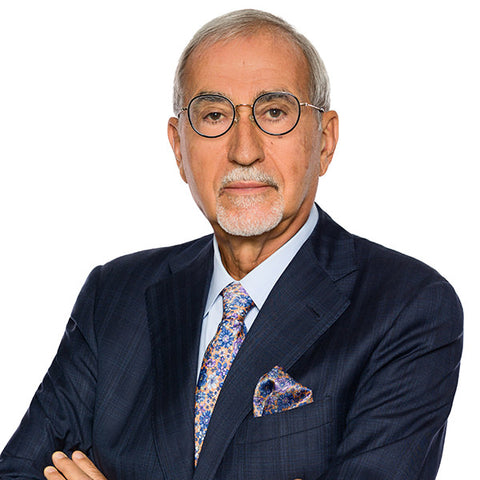 Lawyer headshot of a senior managing partner in a navy suit and glasses, on the firm standard