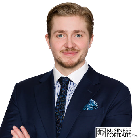Law firm headshot of a new lawyer in a navy suit and patterned tie, photographed to the firm standard