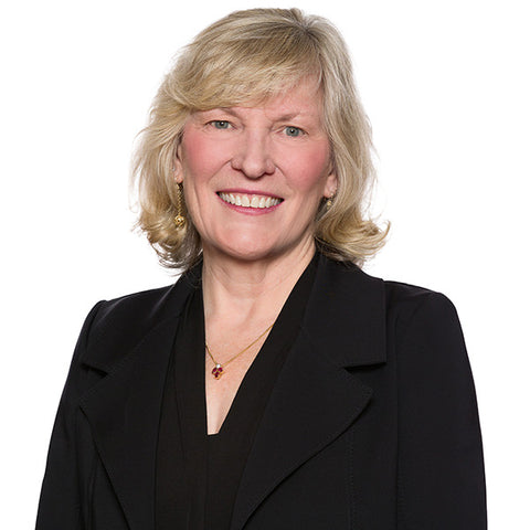 Lawyer headshot of a senior woman lawyer in a black blazer, photographed to the firm standard