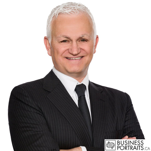 Law firm headshot of a senior partner with silver hair in a dark pinstripe suit, white background